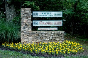 Newly planted marigolds at the base of the sign at the bottom of the driveway